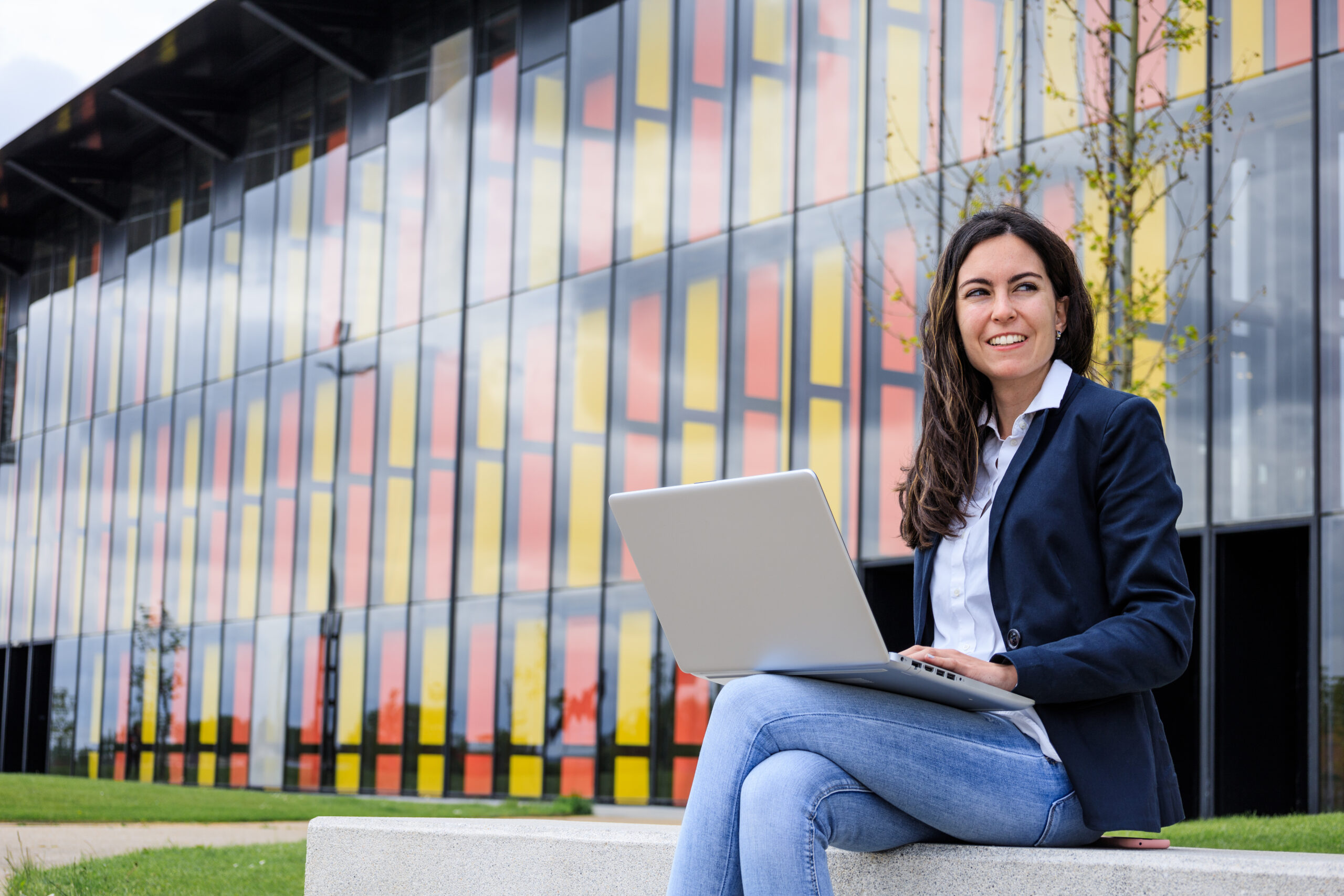 Businesswoman working with laptop in modern park.