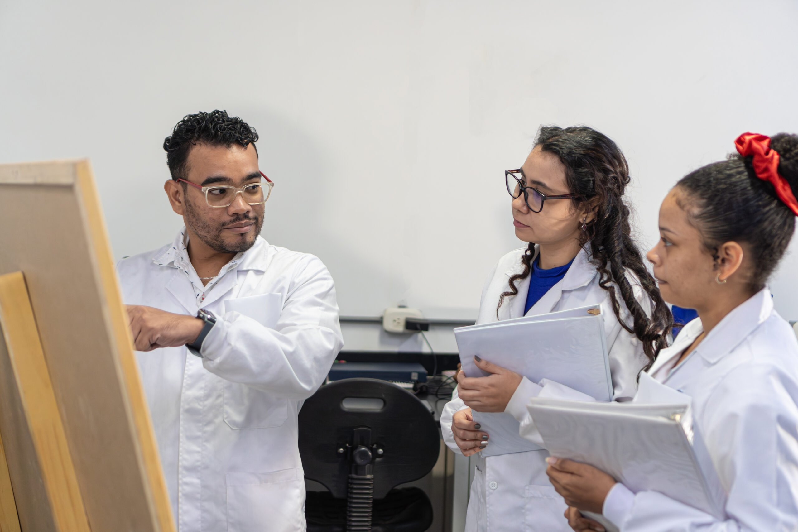 Researcher on a board explaining to her lab partners